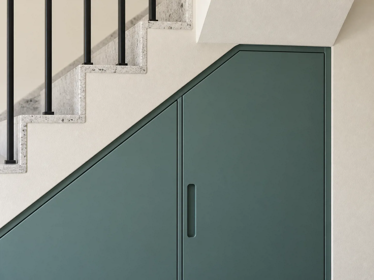 Panel HPL dusty teal dan filler mengikuti bidang miring tangga, dengan finger pull yang menyatu pada muka kabinet.